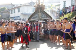 Youths and community members pull a model of a ‘Morung,’ a Naga dormitory, during the Sungkotenem Festival. 