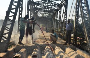 Labourers work in demonetisation of World War II bridge build by British government over Dhansari River in Dimapur, Nagaland on Tuesday, January 17, 2016. Photo by Caisii Mao