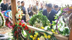 Shurhozelie laying wreaths at the graves of the two Naga youths.