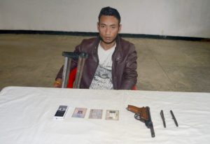 Mukhim Rongpi along with the seized arms and ammunition in Dimapur.