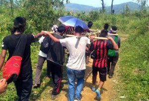 Zangkham Villagers seen carrying a sick person on a bamboo made carrier