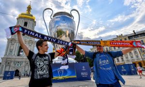 Street vendors pose with their scarves in front of a giant inflatable replica of the Champions League trophy at St Sofia square in central Kiev.