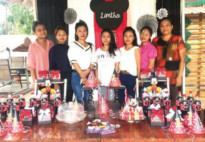 The design team of Quirky Qrafts with the proprietor Asano Peseyie Centre showcasing one of their handmade birthday decor and props.